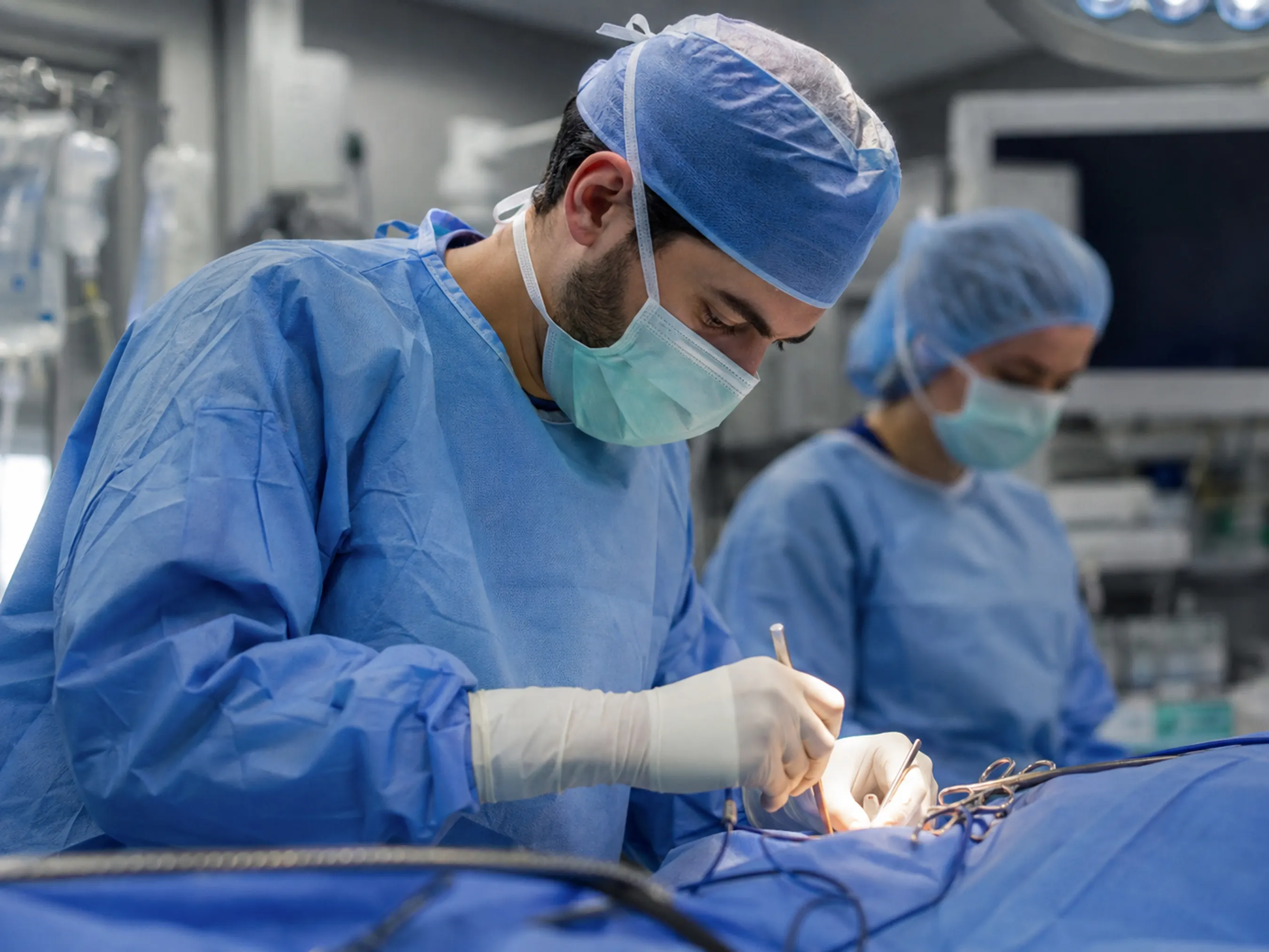 Resident surgeon performing a procedure in an operating room